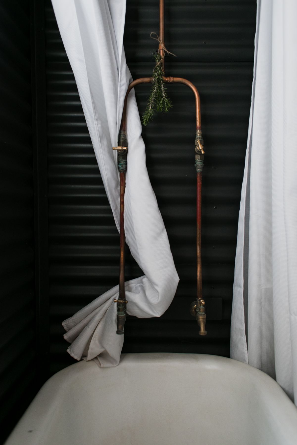 Exposed copper pipework in a bathroom, the plumbing most affected when acidic water is softened without neutralising