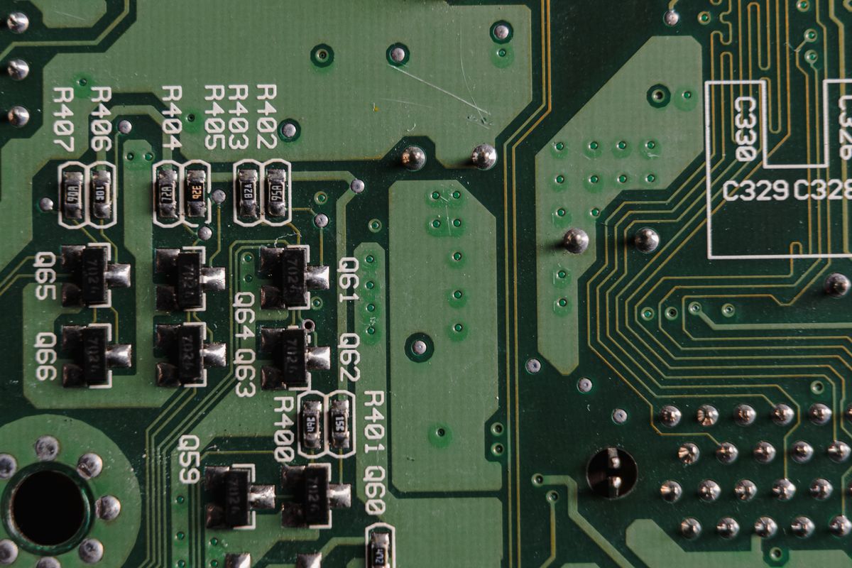 Close-up of a printed circuit board with surface-mounted chips and traces, the kind of control board a softener's position switch or optical sensor reports to
