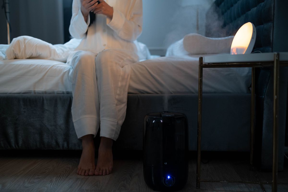 Bedroom at night with humidifier mist lit by soft lamplight
