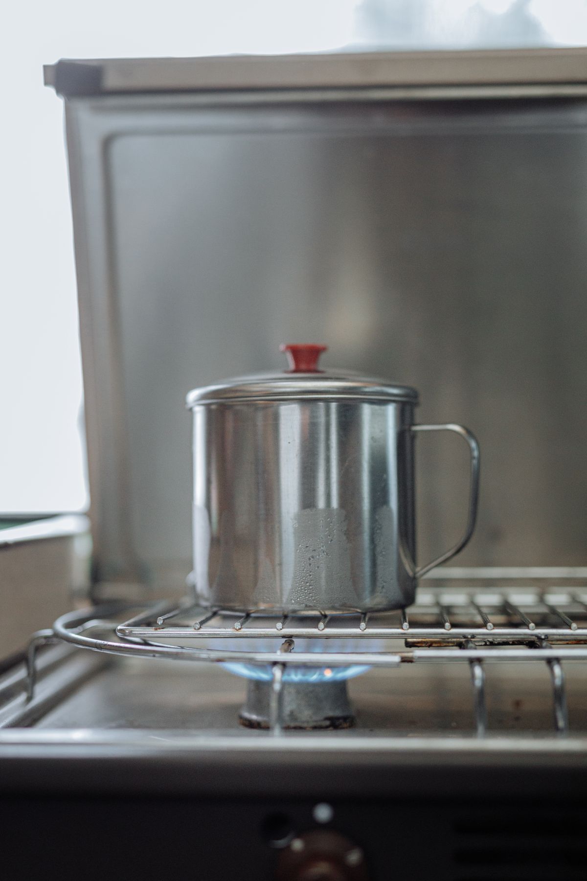 Stainless steel pot heating water on a gas burner, the everyday place where either salt-free conditioner should show less new scale within a few months