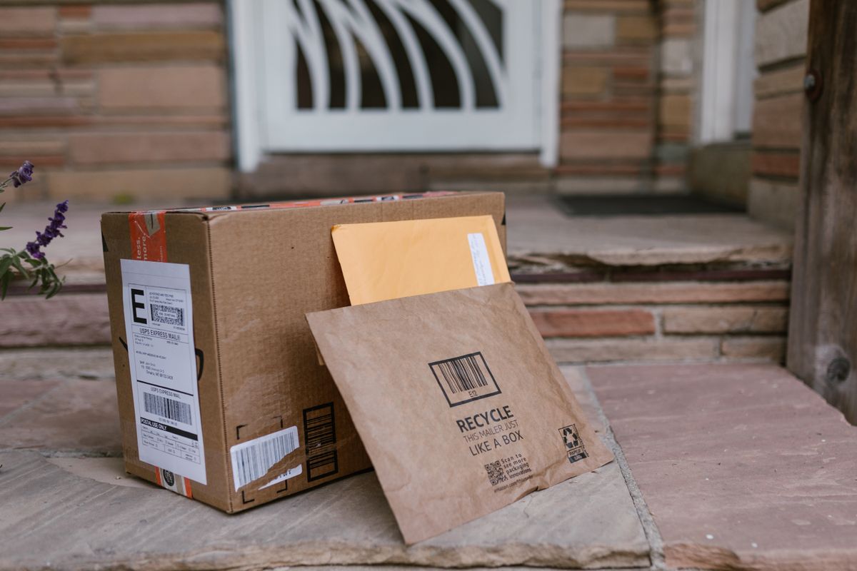 Cardboard shipping box and padded mailers left on a front doorstep, how online water softeners such as Aquasure and SpringWell arrive for self-installation