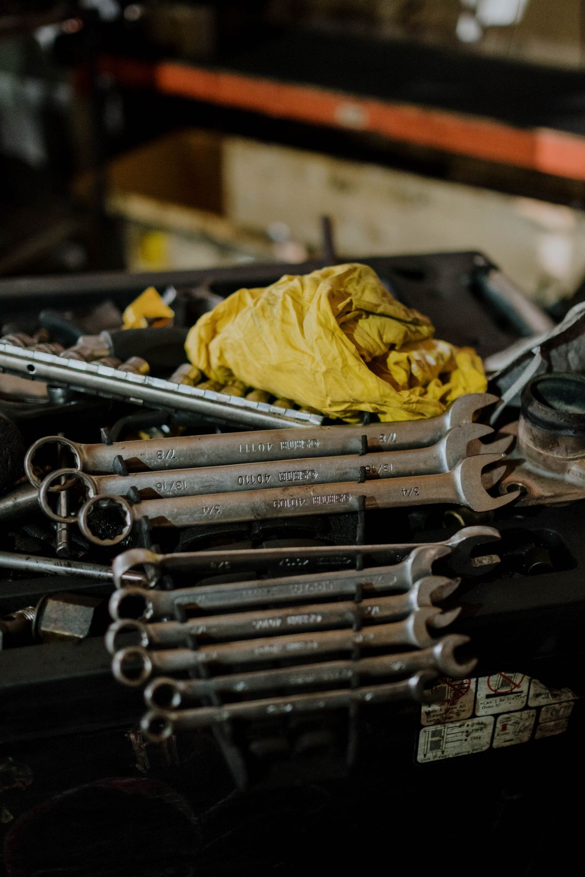 Close-up of a combination wrench set spread across a cluttered workbench, the basic tools that cover most softener fixes but not every one