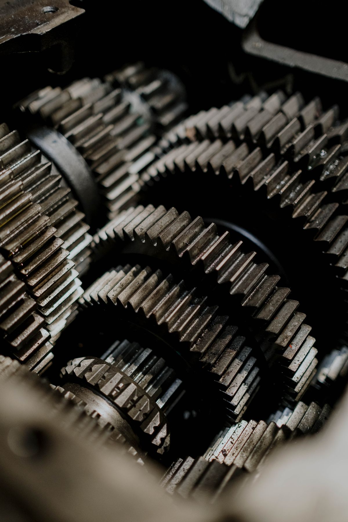 Close-up of interlocking metal gears inside a machine, the kind of drive gear train that turns a water softener valve and grinds or clicks when a tooth strips