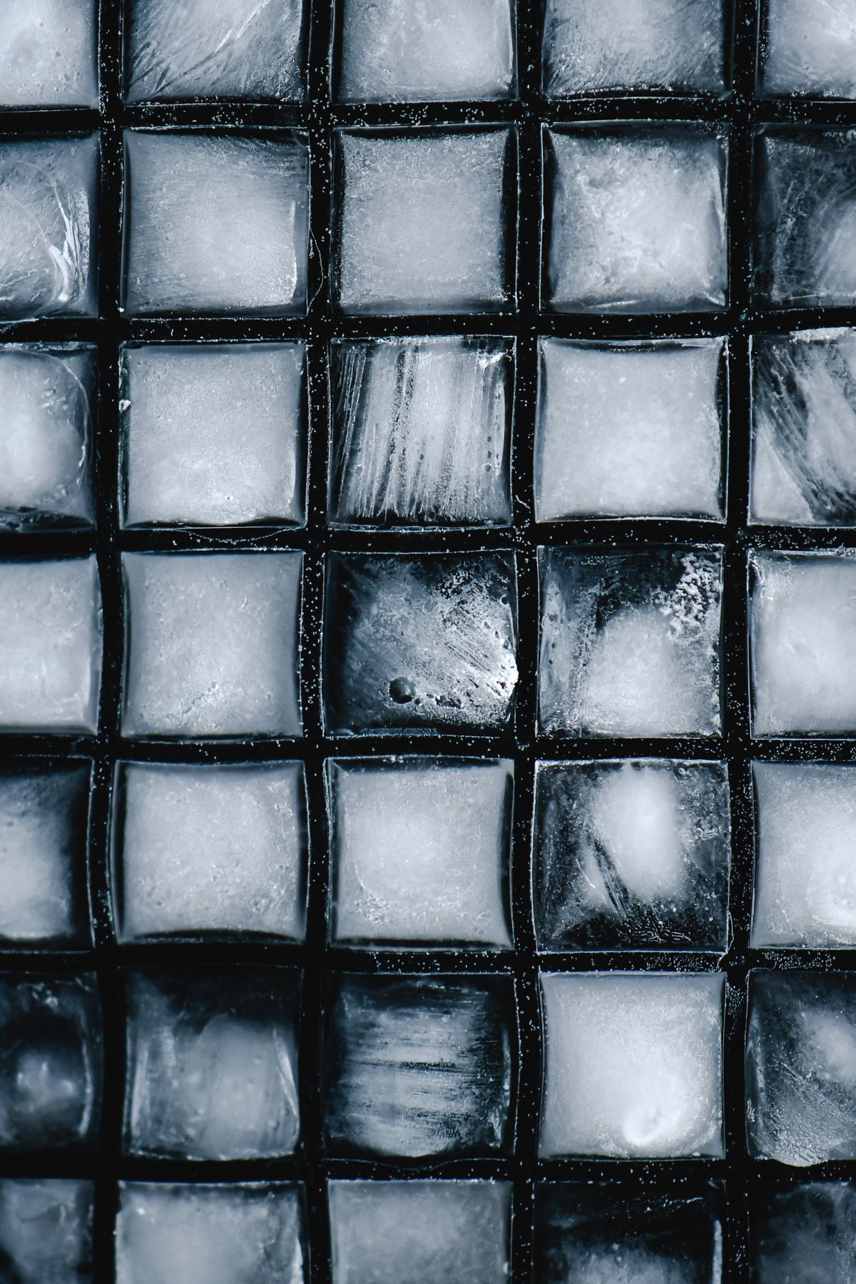 Close-up of ice cubes in a freezer tray showing the cloudy centres common with hard water refrigerator ice maker output