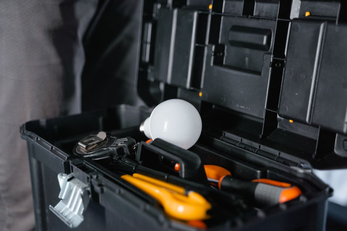 Open black toolbox holding pliers, screwdrivers and wrenches, the kit a homeowner needs to unscrew a control valve and refill a softener tank with new resin