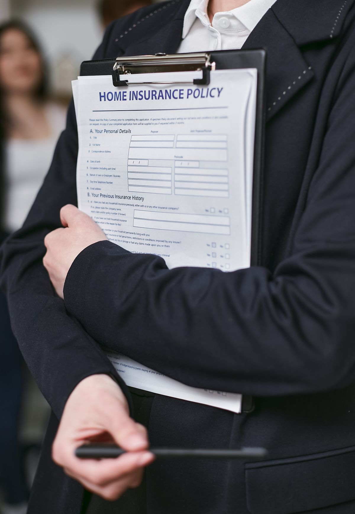 Person holding a home insurance policy document on a clipboard, the paperwork a flood claim for a basement water softener has to be matched against