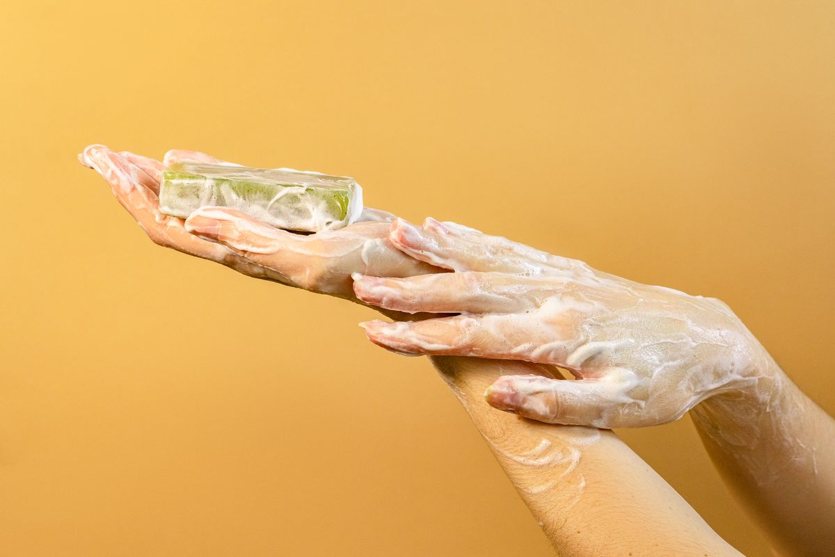 Hands covered in thick soap foam, illustrating why soap won't lather in hard water