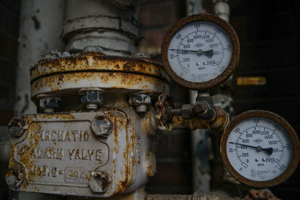 Aged and rusted pressure valve and gauges on old pipework