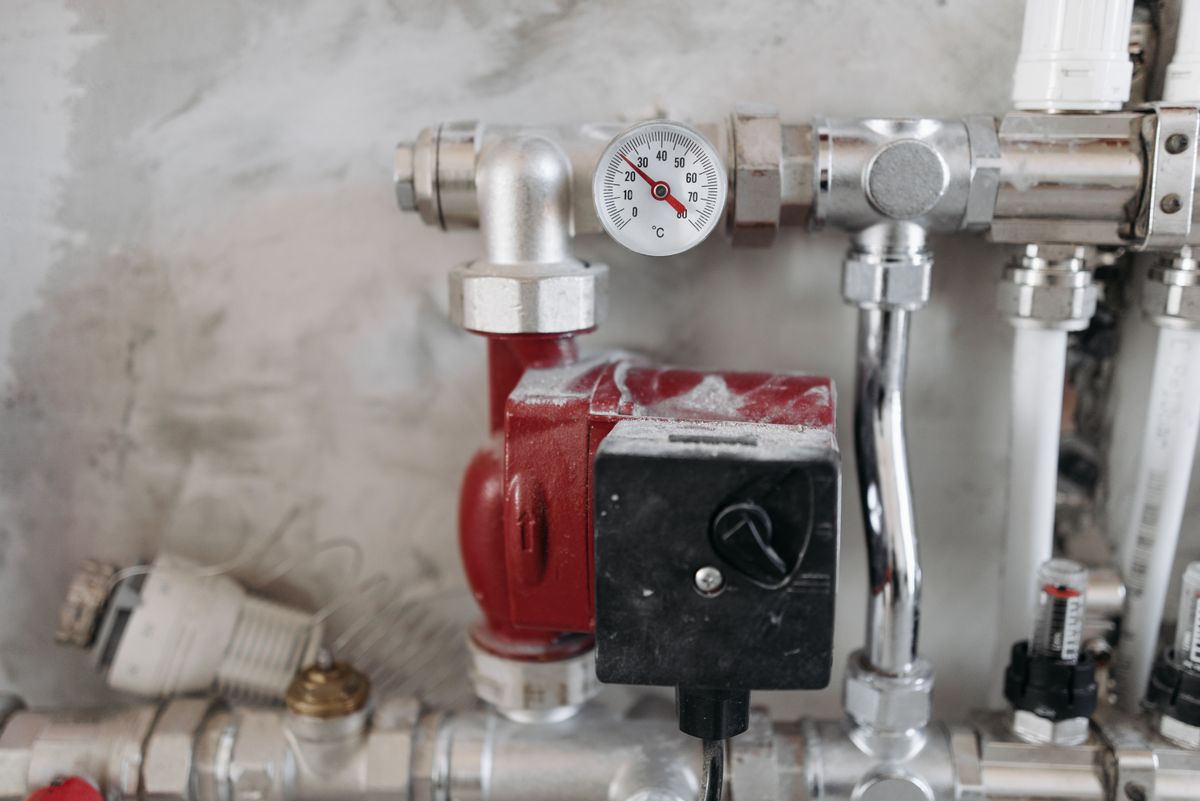 Industrial pressure gauge and steel pipework, illustrating the heated side of a system where calcium carbonate precipitates