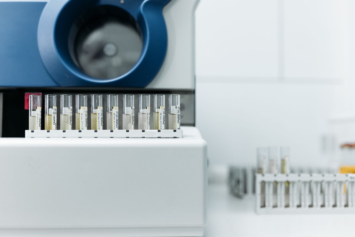 Laboratory analyzer with a rack of sample tubes beside it, where a well water sample's iron result is only as good as the bottle it arrived in