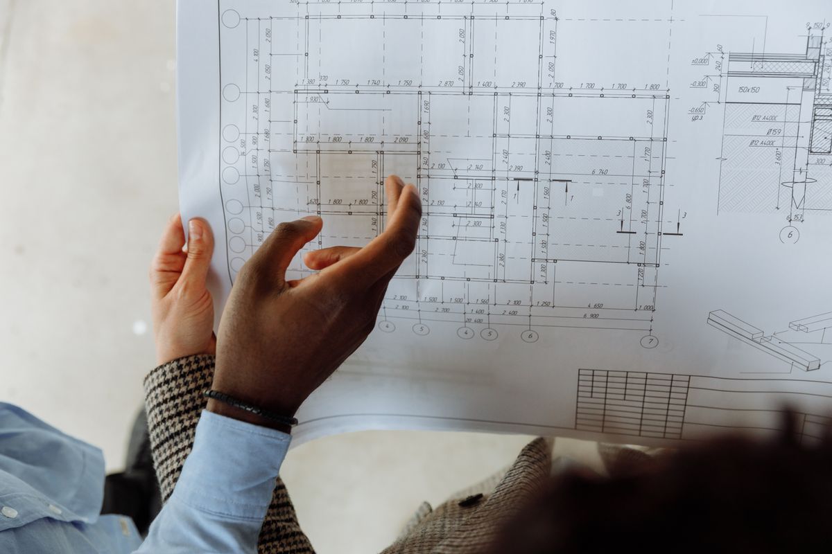 Hands pointing at specific rooms on a detailed architectural blueprint, the step where the hardness pattern reveals the branch