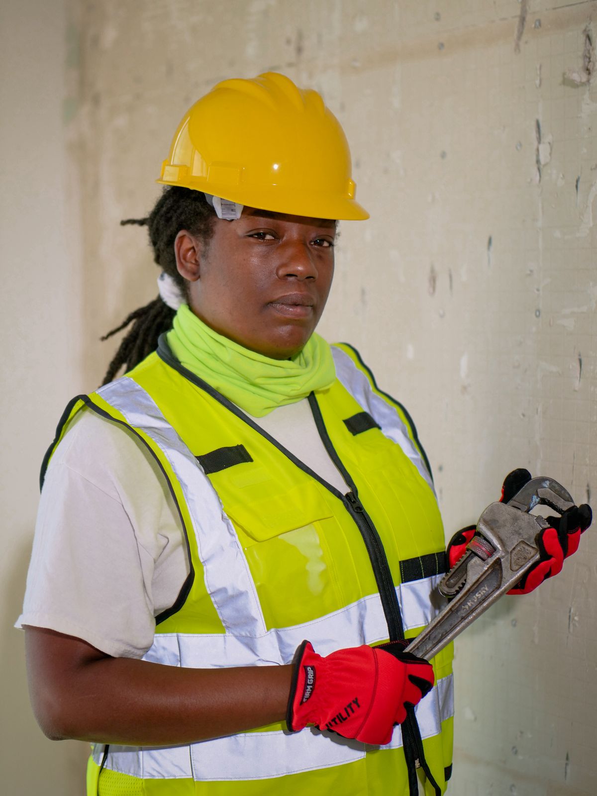 Tradesperson in a hard hat and safety vest holding a pipe wrench, ready for the plumbing work a Clack WS1 softener installation or valve rebuild involves