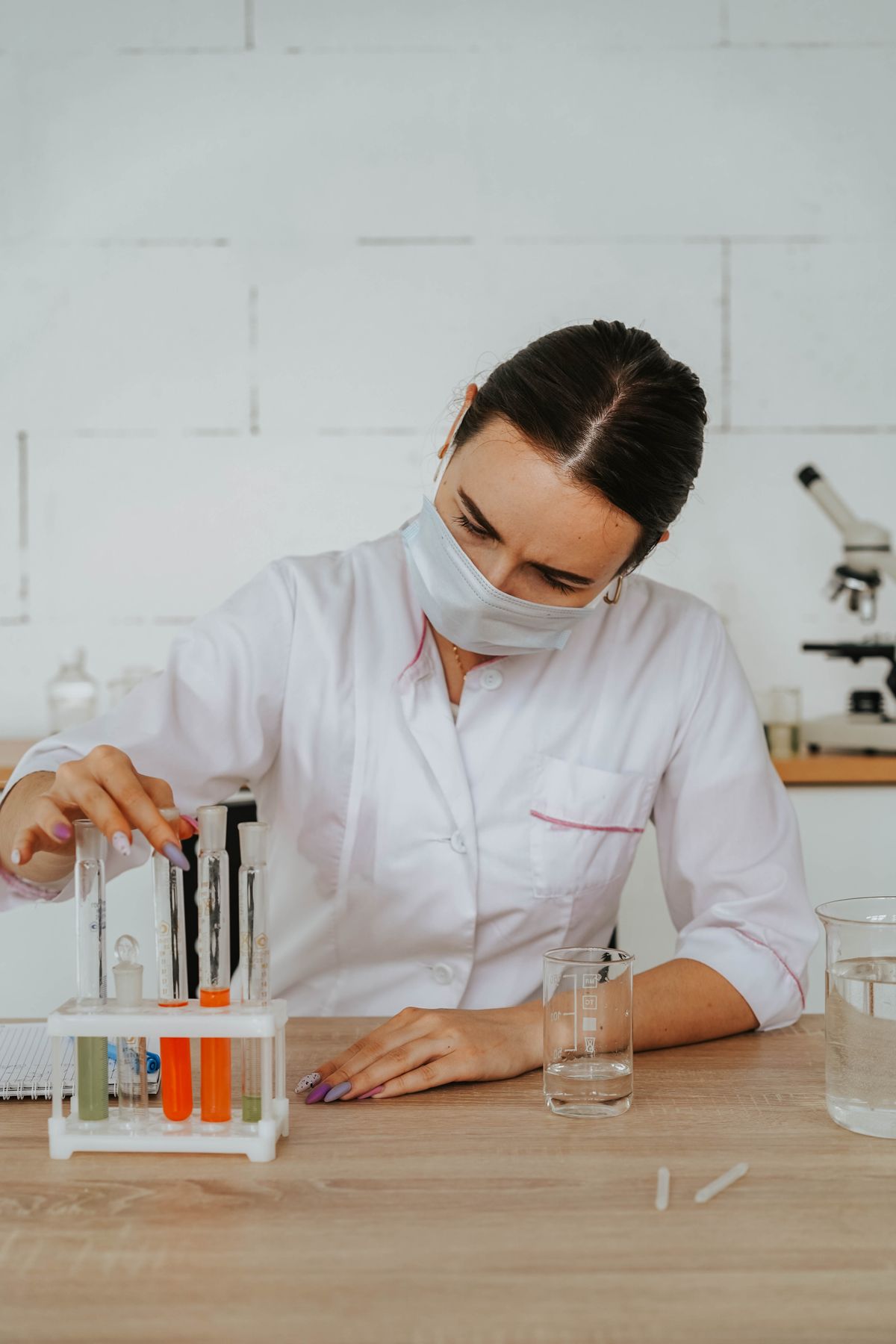 Laboratory technician analysing water samples in test tubes and beakers
