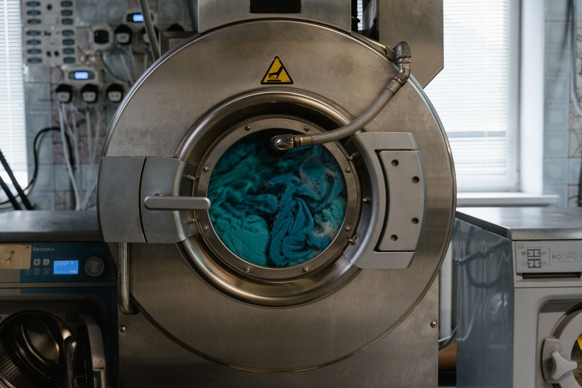 Clothes and fabrics tumbling inside an automatic washing machine drum