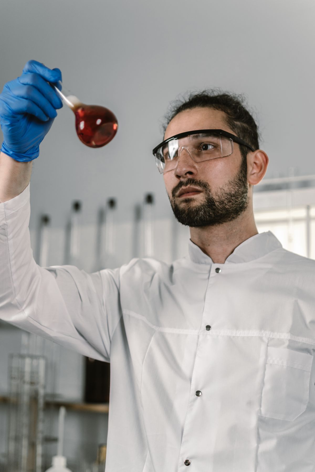 Laboratory technician examining a liquid sample, the certified analysis required to rule out lead in a metallic-tasting supply