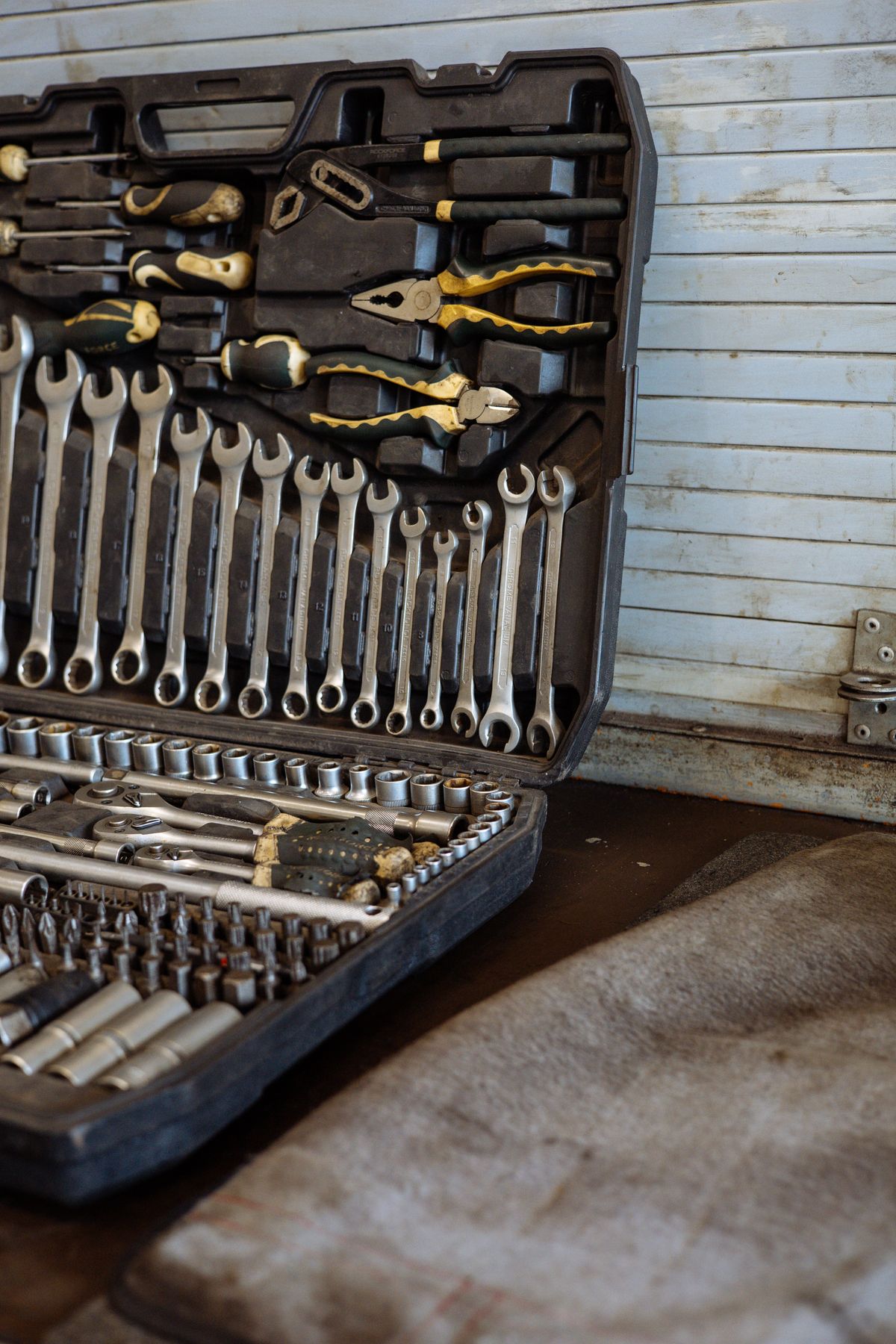 Open case of wrenches, pliers and sockets on a workbench, the basic tools a homeowner needs to rebuild a water softener valve when the brand sells its parts