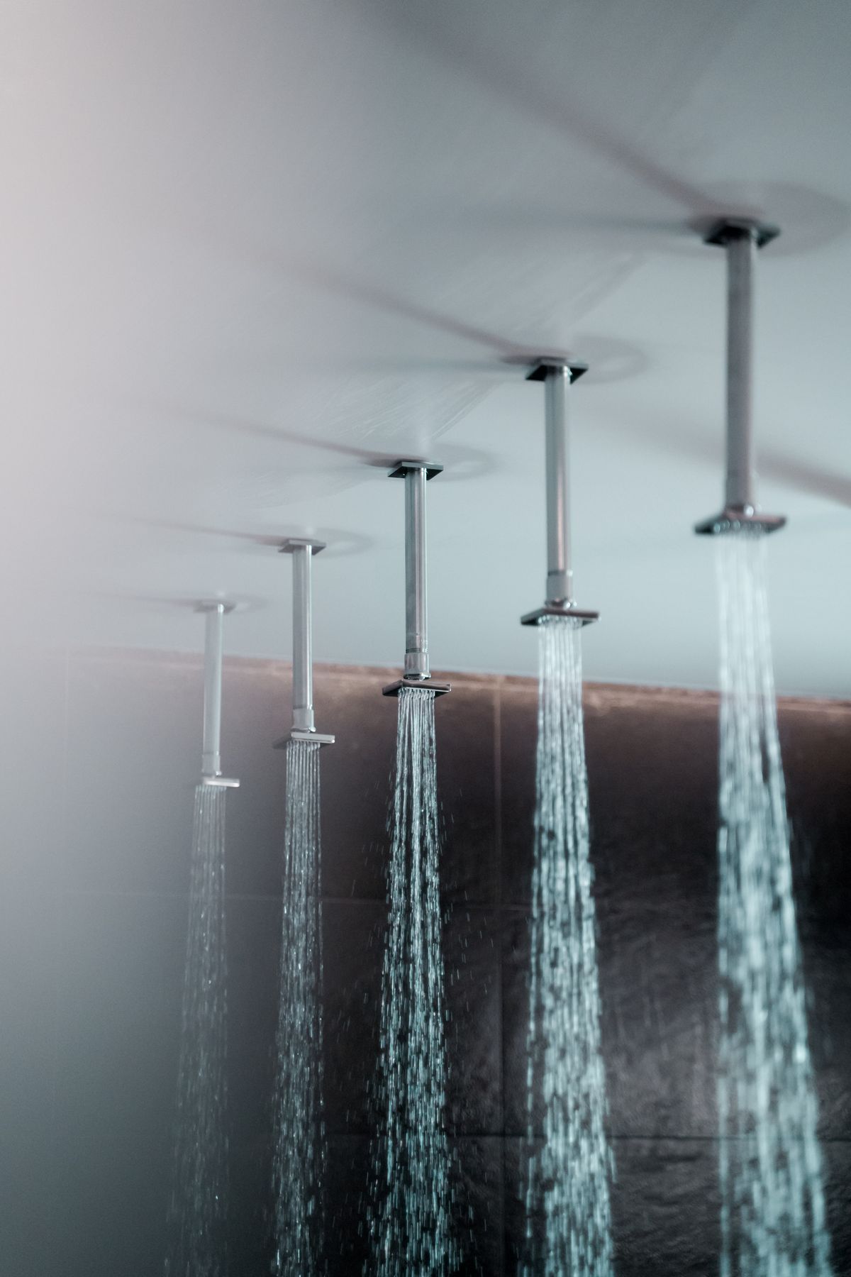 Five ceiling-mounted rain shower heads running at once, simultaneous demand that a water softener's peak flow rate has to carry