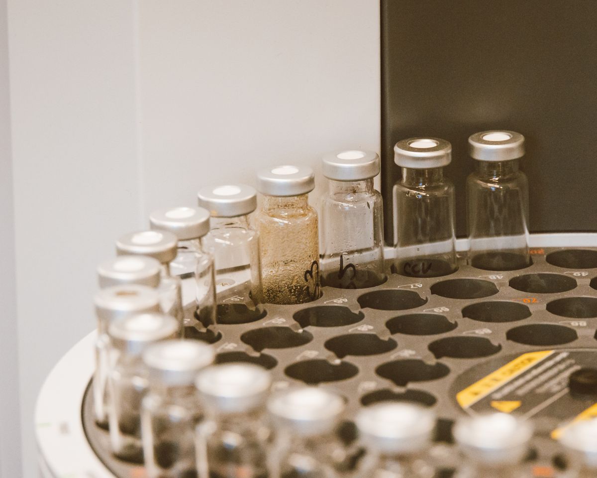 Rows of small glass sample vials loaded in a laboratory autosampler, the kind of analysis that turns a well's iron into a number you can check against a softener rating
